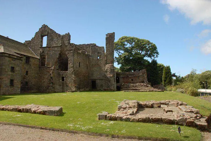 Aberdour Castle ruins behind low stone foundations on the lawn