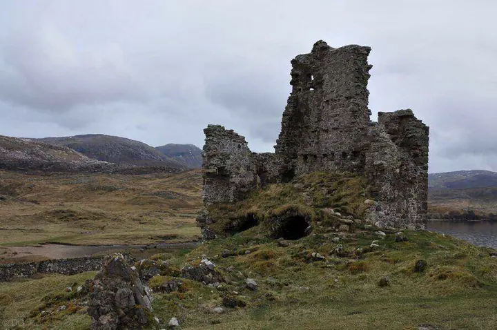 Broken walls of Ardvreck Castle above a rocky grass-covered mound