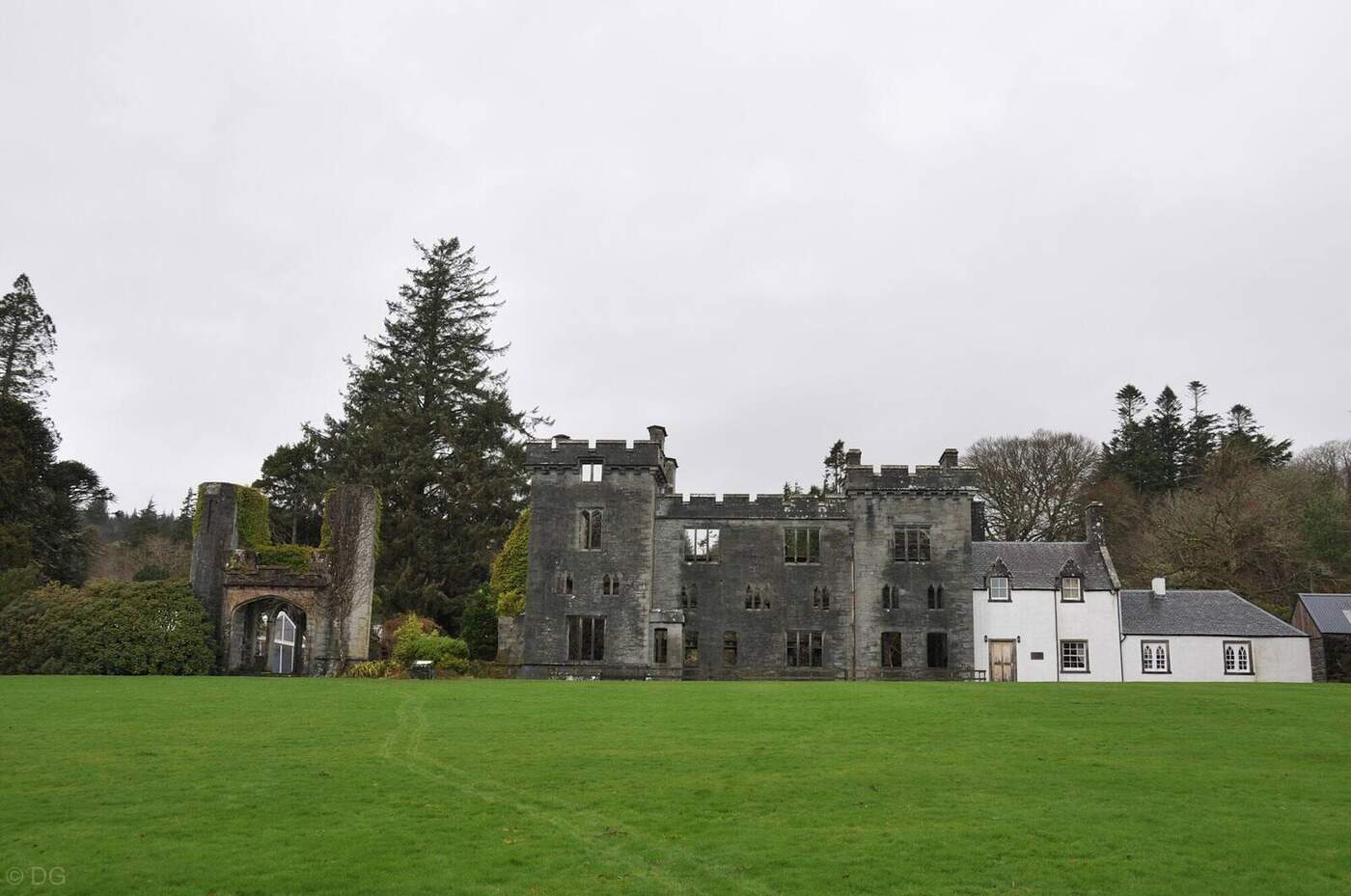 Armadale Castle's ruined facade and adjoining white buildings beyond the lawn
