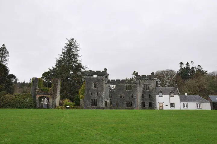 Armadale Castle's ruined facade and adjoining white buildings beyond the lawn