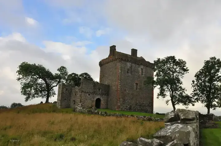Balvaird Castle beyond a meadow with tall grass