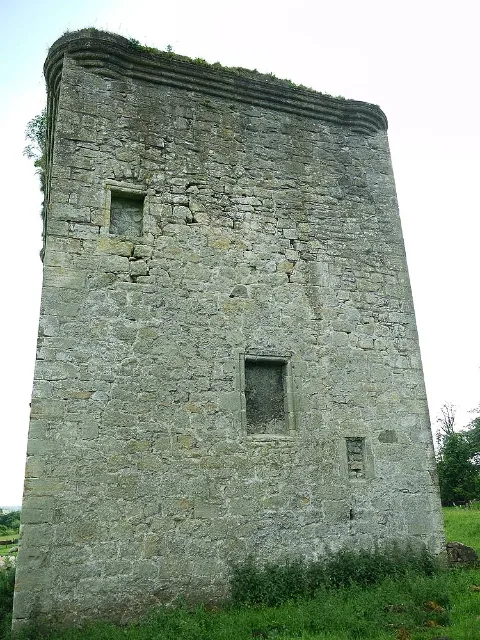 Full-height stone wall of Barr Castle with several blocked openings and grass below.