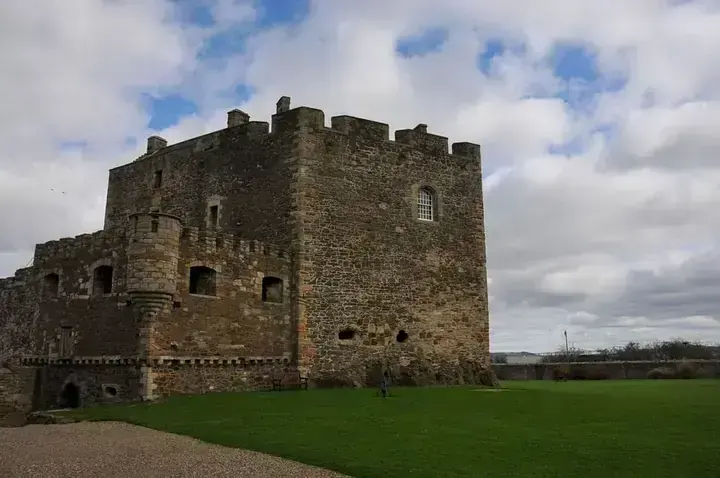 Crenellated tower of Blackness Castle viewed across the lawn