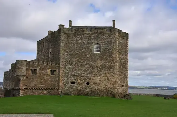 Crenellated tower of Blackness Castle with water in the background