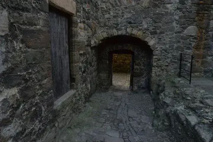 Cobblestone passage beneath a stone arch at Blackness Castle