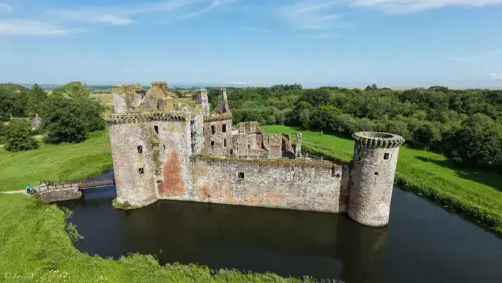 Caerlaverock Castle and its round towers seen from above the moat