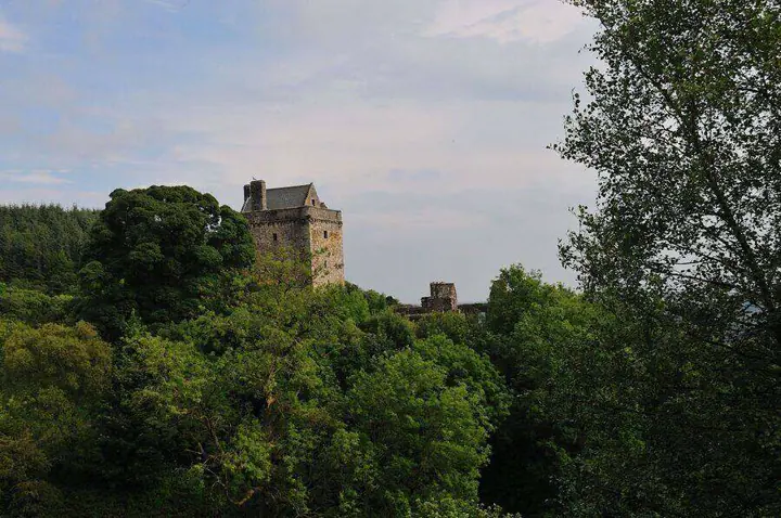 Castle Campbell tower partly hidden by dense green trees