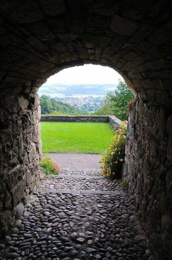 Stone arch framing the lawn and distant landscape at Castle Campbell