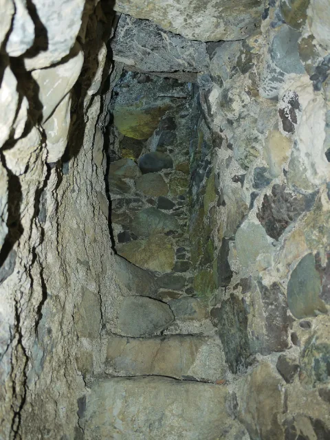 Narrow stone passage with worn steps inside Carleton Castle