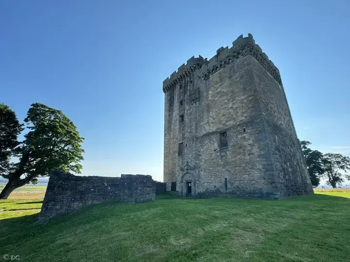 Clackmannan Tower and low ruins beneath a clear blue sky