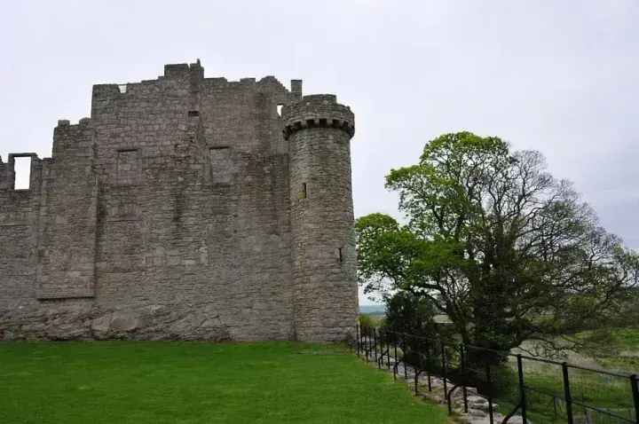 Craigmillar Castle round turret beside a large leafy tree