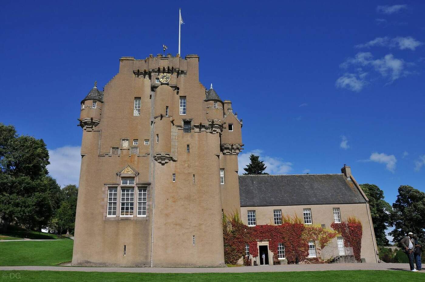 Crathes Castle tower with projecting turrets beside an ivy-covered wing