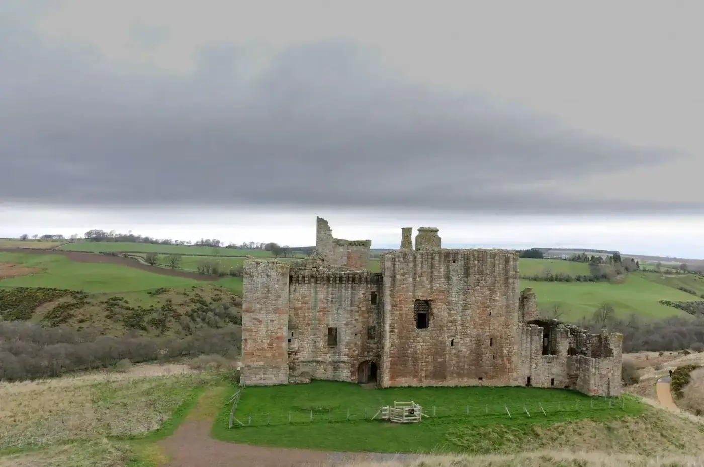 Crichton Castle ruins above a grassy slope and green fields