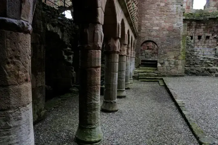 Row of stone columns and arches at Crichton Castle
