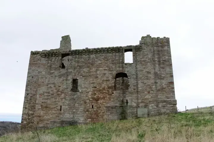 Tall outer wall of Crichton Castle with empty windows