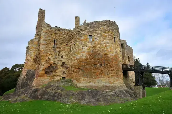 Dirleton Castle's round tower and raised entrance bridge above the rock