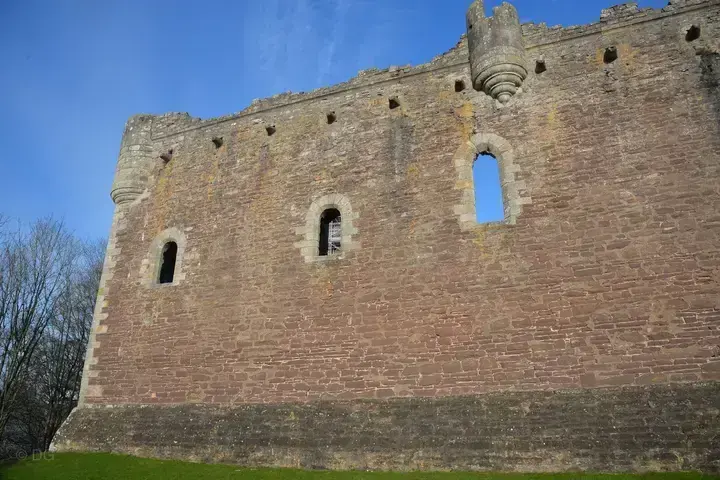 Doune Castle's long outer wall with arched windows and projecting turret