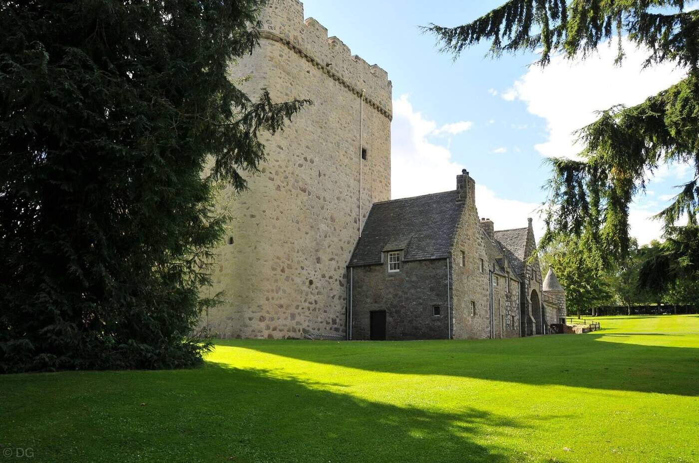 Drum Castle stone tower and adjoining building framed by trees