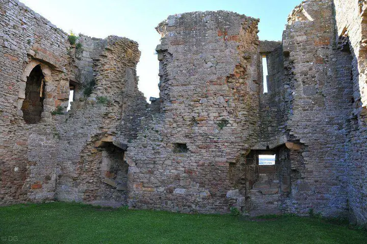 Roofless interior of Duffus Castle with doorways and narrow windows