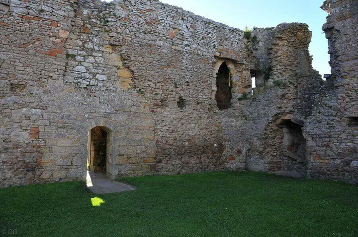 Grass courtyard within Duffus Castle ruins and an open doorway