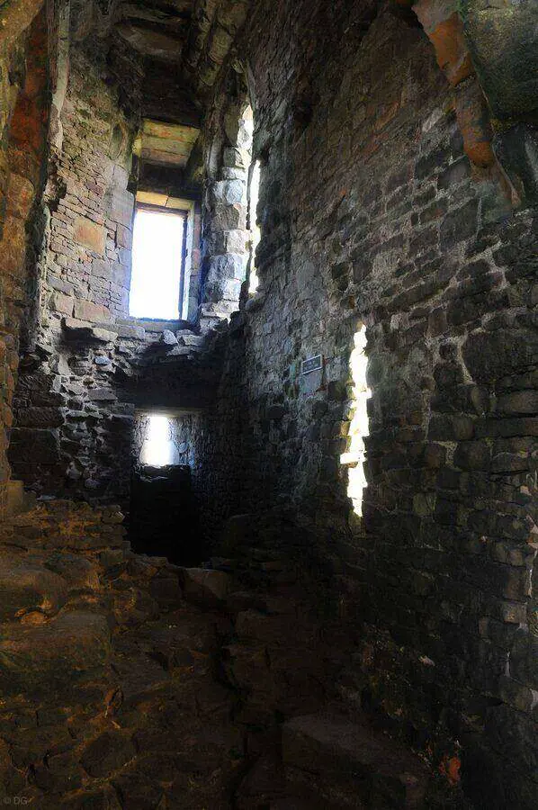 Narrow stone interior at Duffus Castle lit by window openings