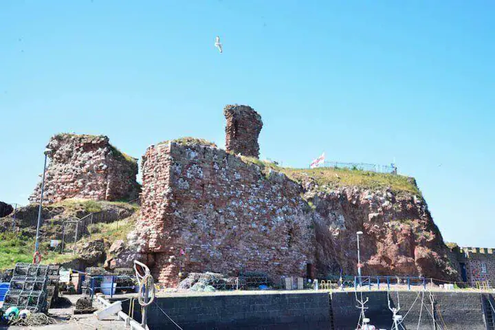 Dunbar Castle ruins rising above harbour walls and boat masts