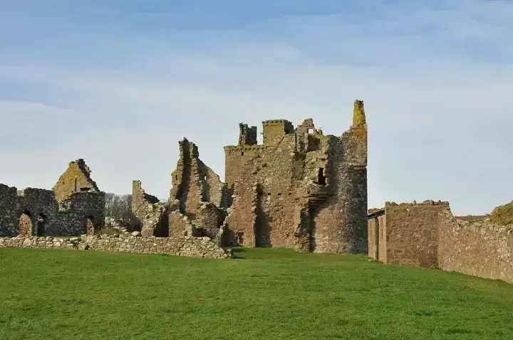 Dunnottar Castle tower behind broken gables and roofless walls