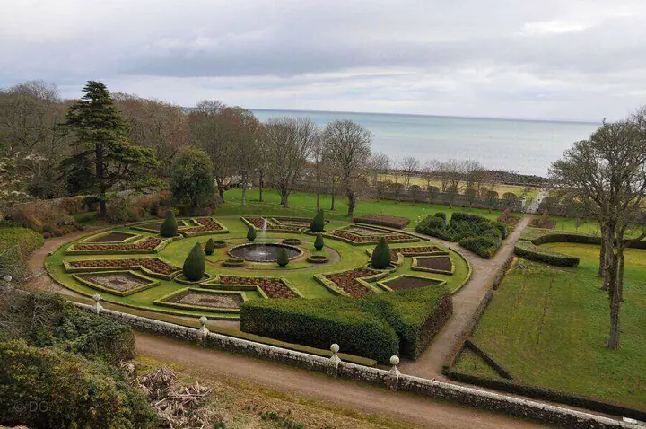 Formal gardens and central fountain below Dunrobin Castle overlooking the sea
