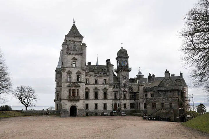 Dunrobin Castle entrance façade and clock tower across a gravel courtyard