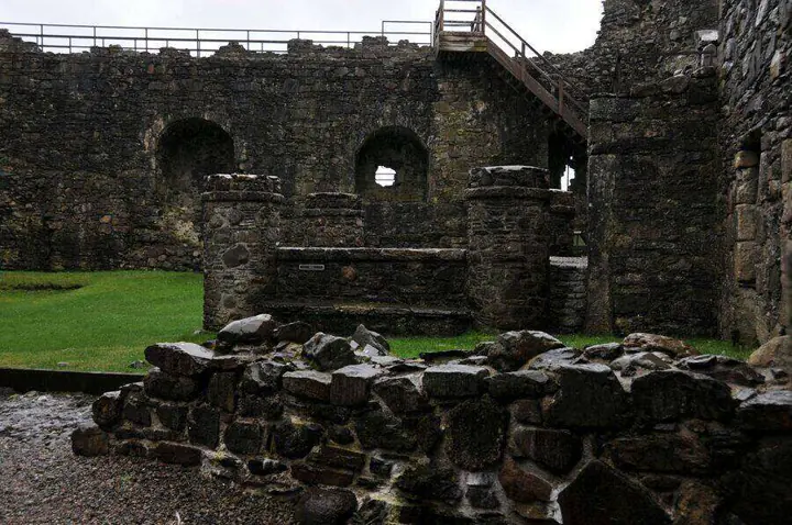 Roofless stone structures within Dunstaffnage Castle courtyard