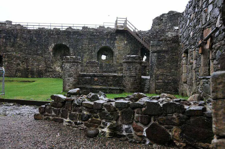 Roofless stone structures within Dunstaffnage Castle courtyard