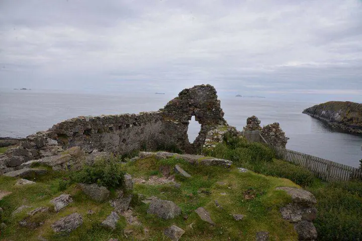 Ruined wall with an arched opening at Duntulm Castle overlooking the sea