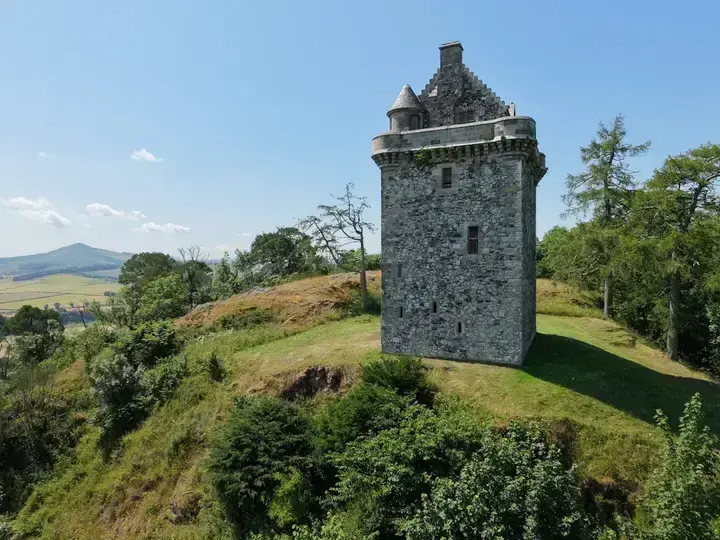 Fatlips Castle tower above a green hillside and open countryside