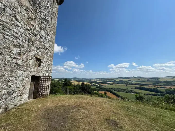 Fatlips Castle doorway beside a grassy terrace with distant fields