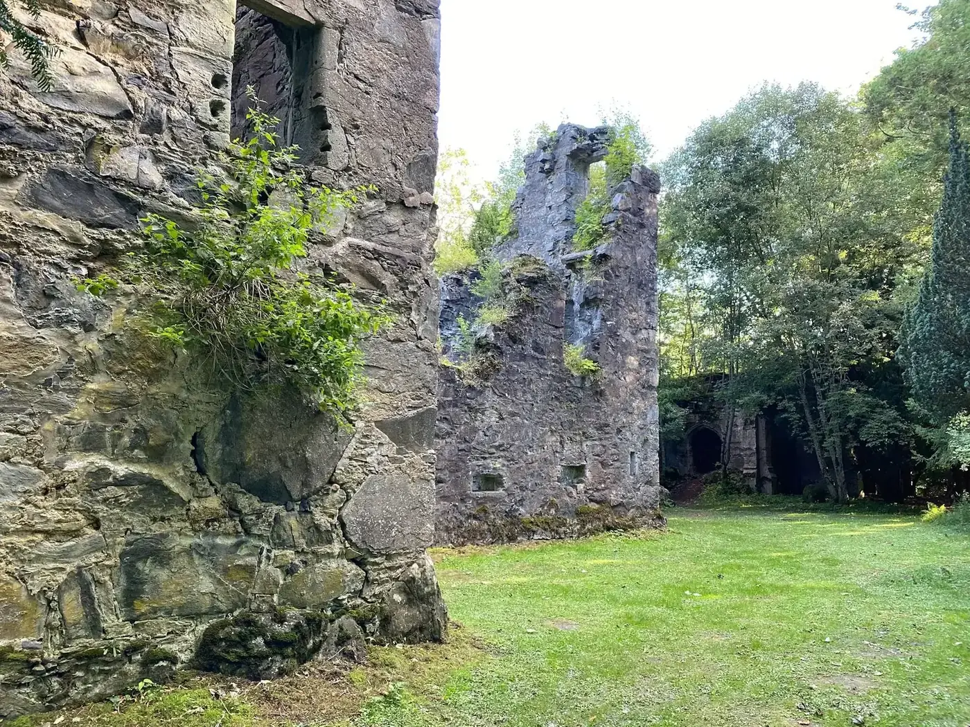 Finlarig Castle ruins opening onto a grassy clearing