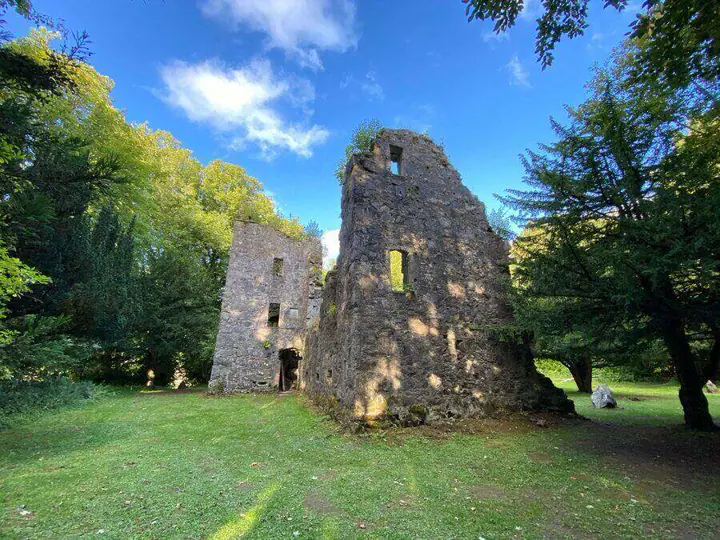 Tall ruined walls of Finlarig Castle surrounded by trees