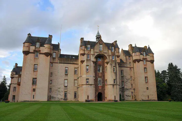 Fyvie Castle facade viewed at an angle across the lawn