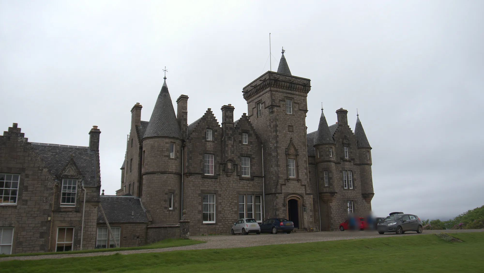 Glengorm Castle front entrance and towers beside a green lawn