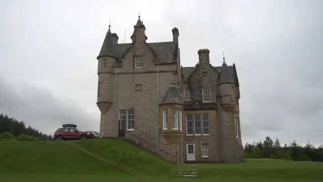 Narrow side of Glengorm Castle with turrets above a sloping lawn