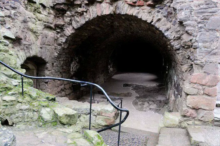 Arched stone entrance with steps and a handrail at Hailes Castle