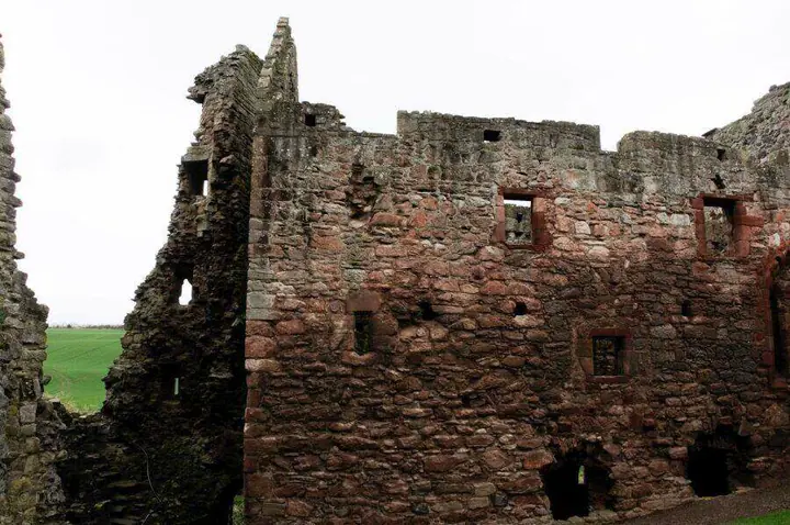 Red sandstone interior wall and empty windows at Hailes Castle