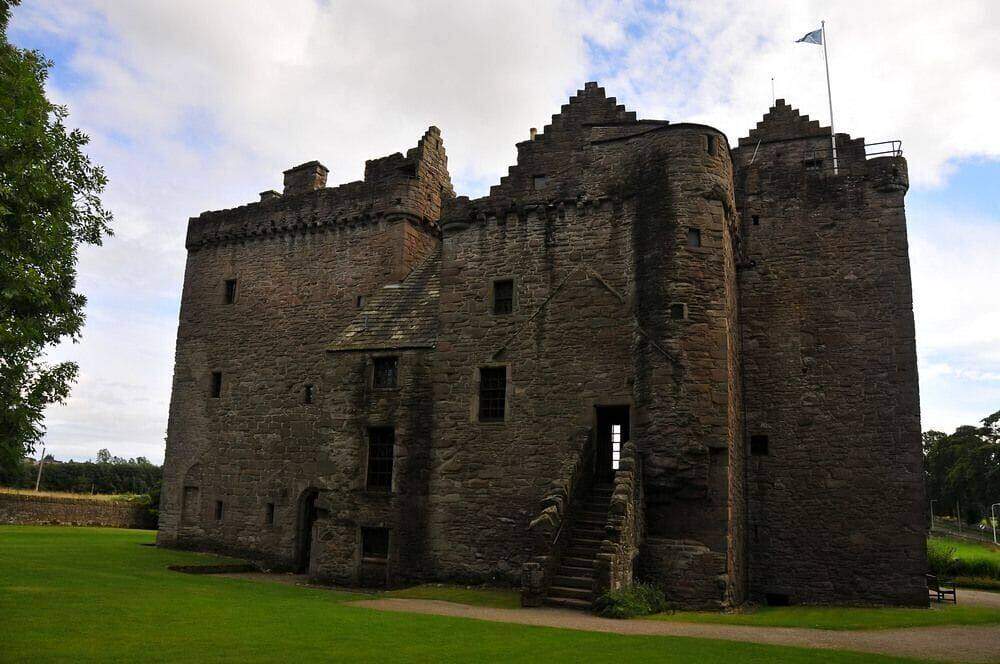 Huntingtower Castle stone towers and exterior stairs above the lawn