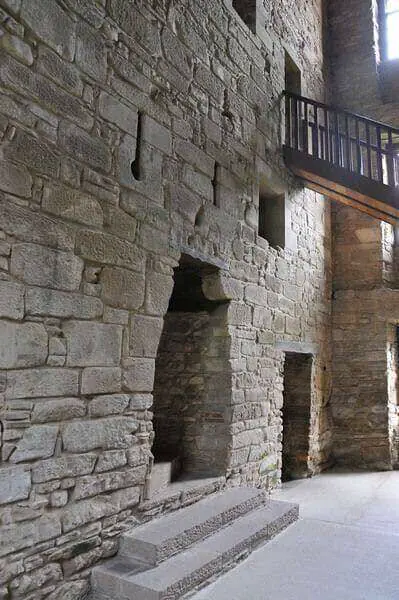 Large stone fireplace beneath a wooden walkway at Huntingtower Castle