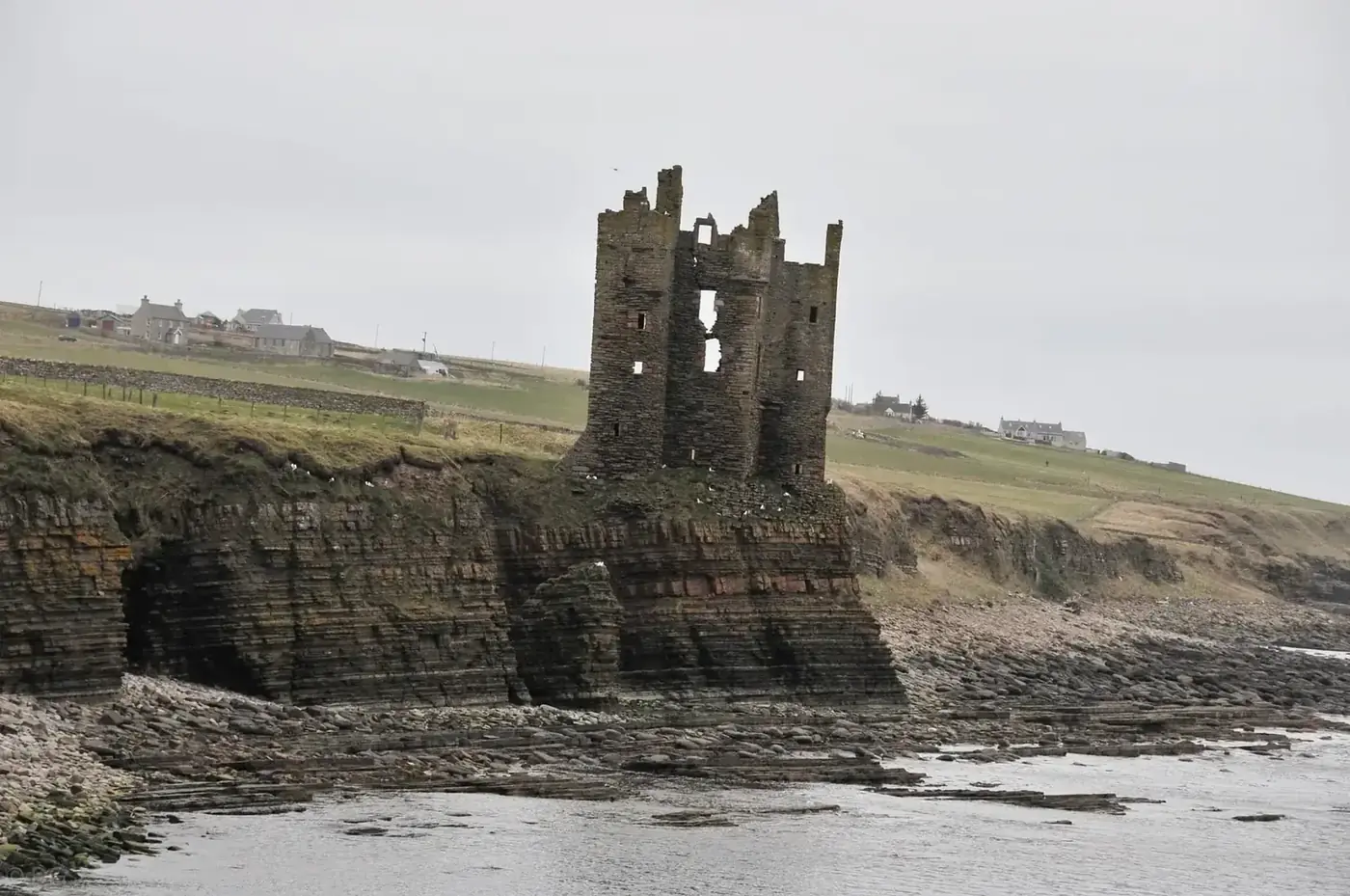 Keiss Castle's roofless tower on layered sea cliffs