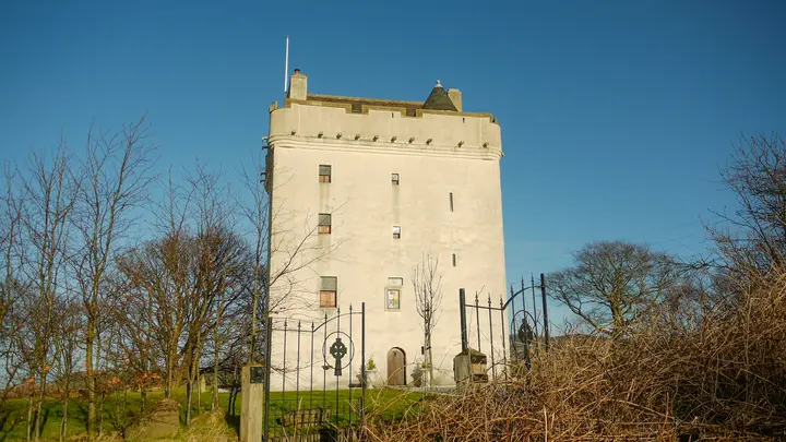 Law Castle seen through an iron gate and bare branches