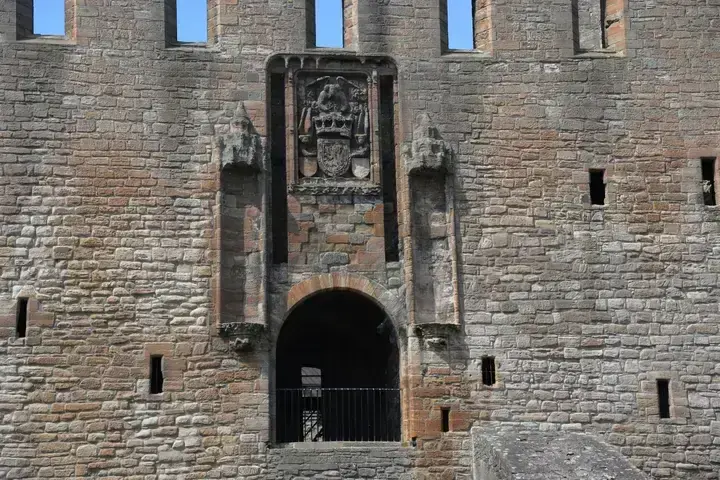 Arched entrance and carved stone panel on Linlithgow Palace façade