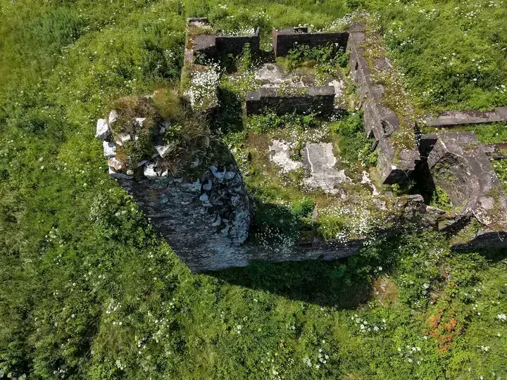 Lochwood Castle stone tower remnant surrounded by overgrown ruins