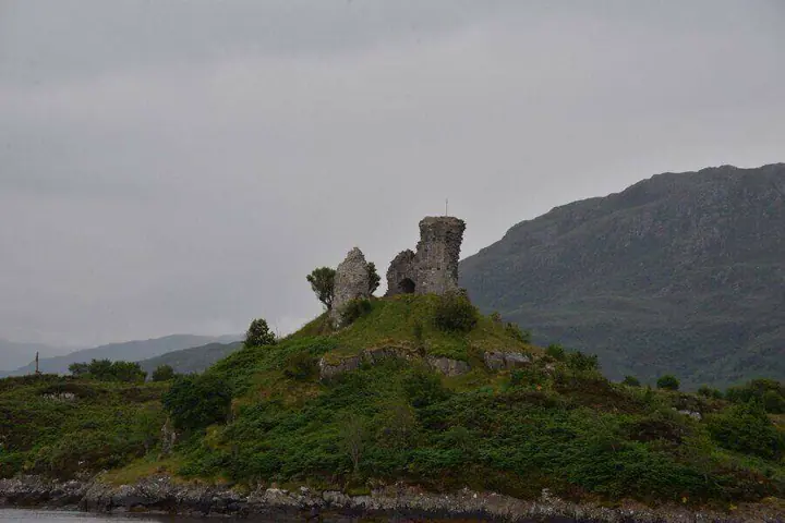 Maol Castle ruins against a dark mountain slope