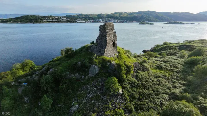 Aerial view of a standing wall at Maol Castle overlooking the water