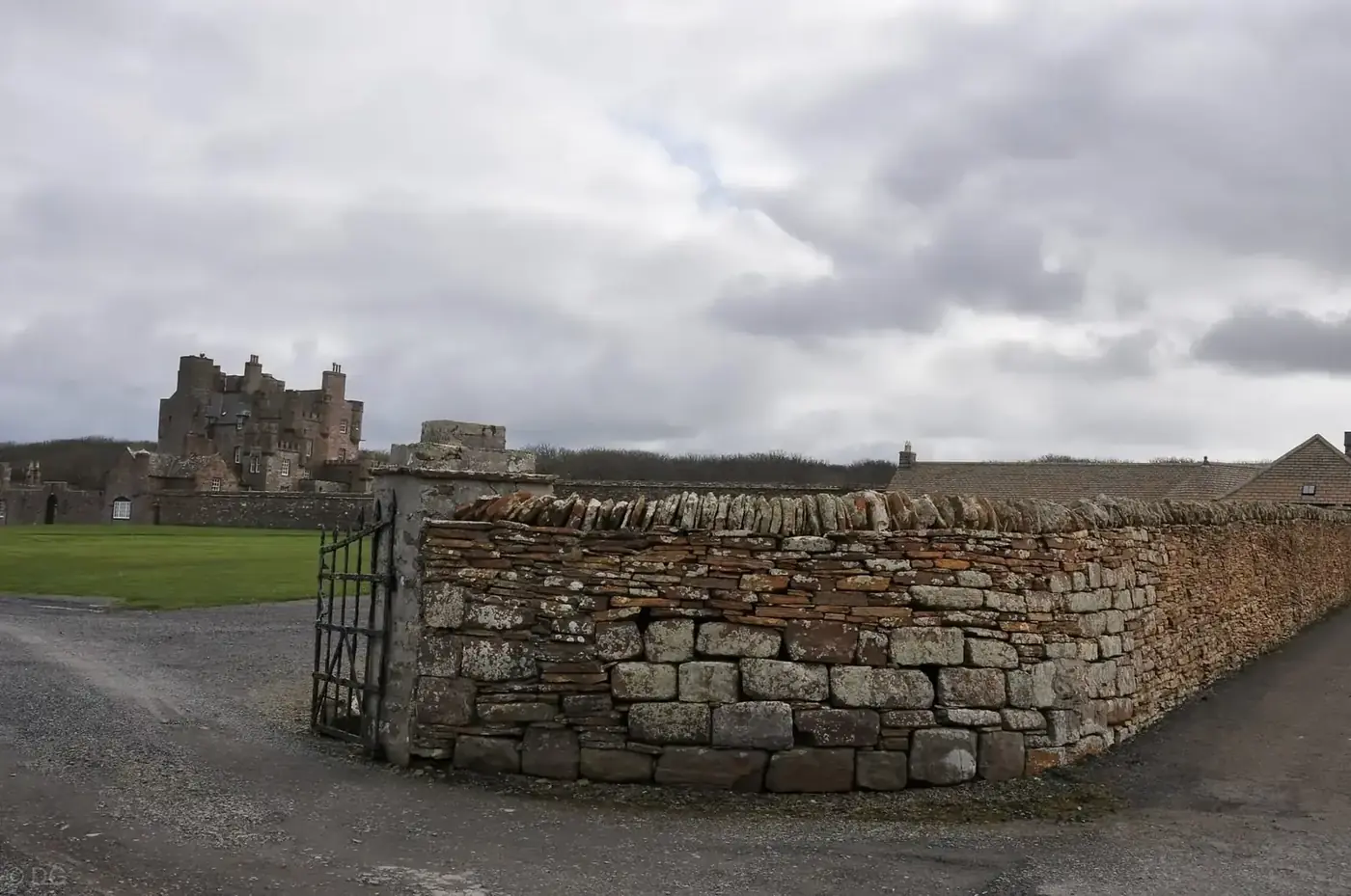 Castle of Mey beyond a stone boundary wall and iron gate